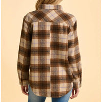 Plaid shirt worn by a person on a beige background