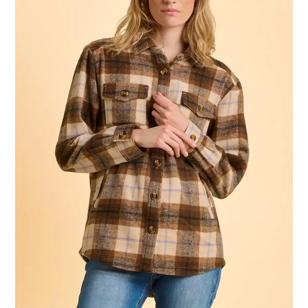 Woman wearing a plaid shirt and jeans on a beige background