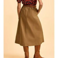 Person wearing a brown skirt with a plain background