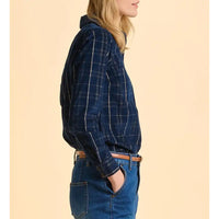 Person wearing a blue plaid shirt and jeans on a beige background