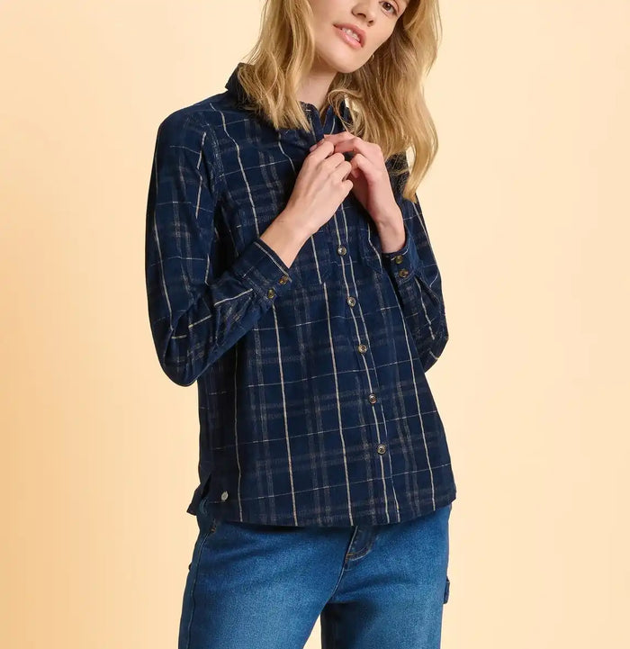 Woman wearing a blue plaid shirt and jeans on a beige background