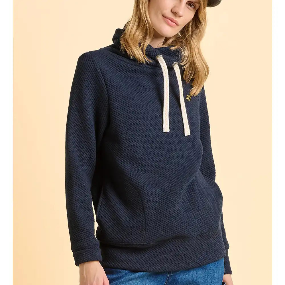 Person wearing a navy blue hoodie with a beige background