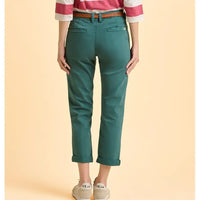 Person wearing teal pants with a red and white striped shirt on a beige background