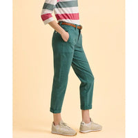 Person wearing green pants and a striped shirt on a beige background