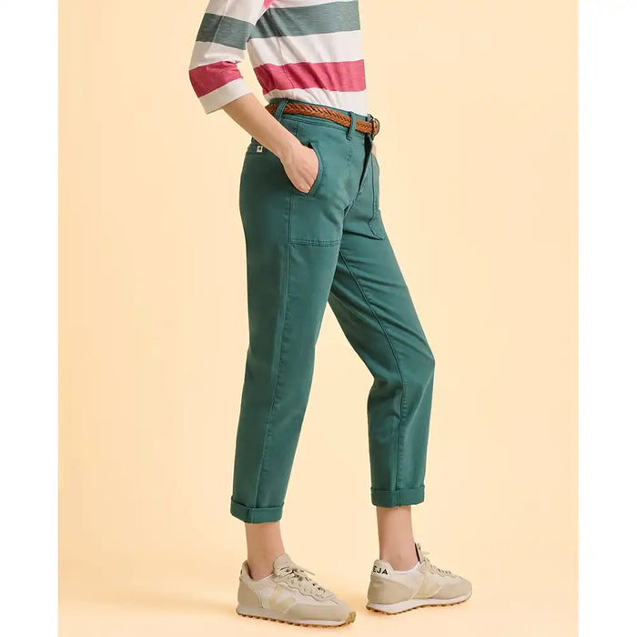 Person wearing green pants and a striped shirt on a beige background