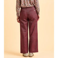 Maroon pants worn by a person on a beige background