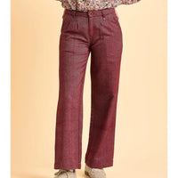 Maroon pants worn with a floral top on a beige background