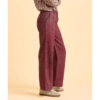 Maroon high-waisted pants worn by a person on a beige background