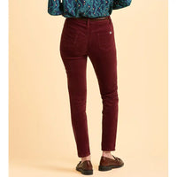 Maroon pants worn by a person on a beige background