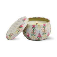 Lidded floral patterned tin containing candle