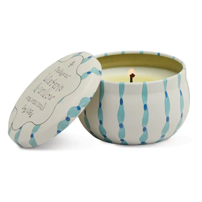 Candle in a decorative tin with a striped pattern on a white background