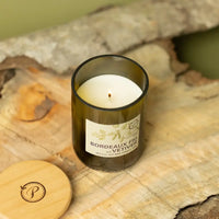 Candle in a wine bottle with a label on a stone surface