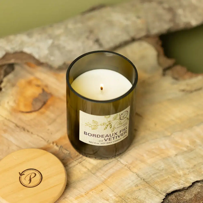 Candle in a wine bottle with a label on a stone surface