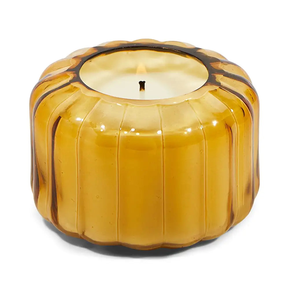 Decorative candle in a glass pumpkin container on a white background