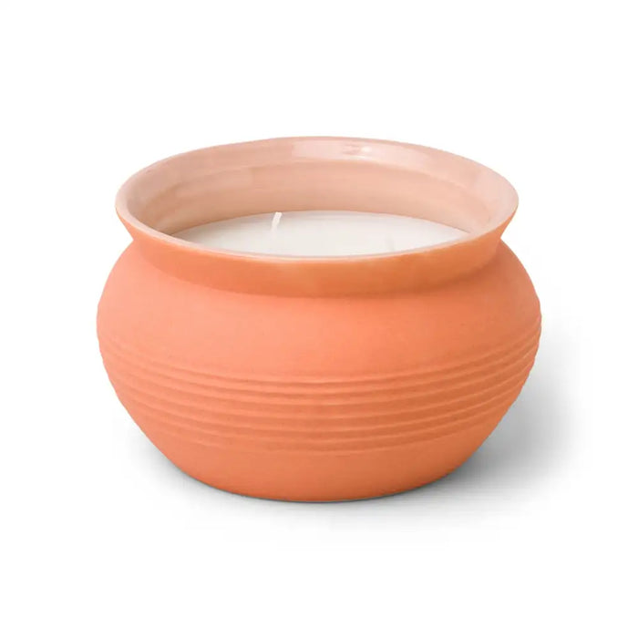 Ceramic candle holder with a candle inside on a white background