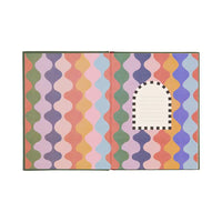 Colorful geometric patterned rug with a white center on a white background