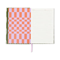 Internal view of notebook. Left page is orange and lilac square pattern. Right page is cream with lines. 