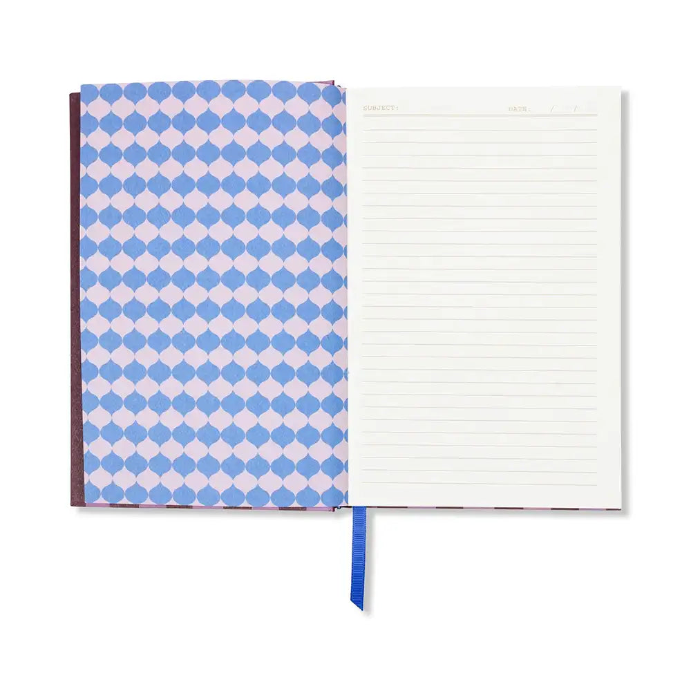Internal view of notebook. Left page is blue and lilac geometric pattern. Right page is cream with lines. 