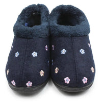 A pair of navy blue slip-on slippers with a plush navy blue lining and embroidered small flowers in pink, blue, and white, shown against a plain white background.