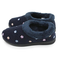 A pair of navy blue slip-on slippers with a plush faux-fur collar and small embroidered floral details in pink, blue, and beige, shown on a white background.