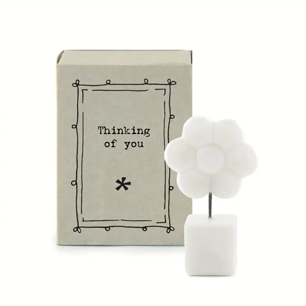 White porcelain cube base with black wire leading to white porcelain flower. Gift box in background.