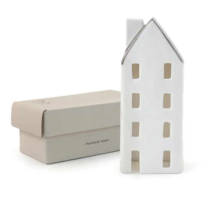 White ceramic house-shaped object with a matching box on a white background