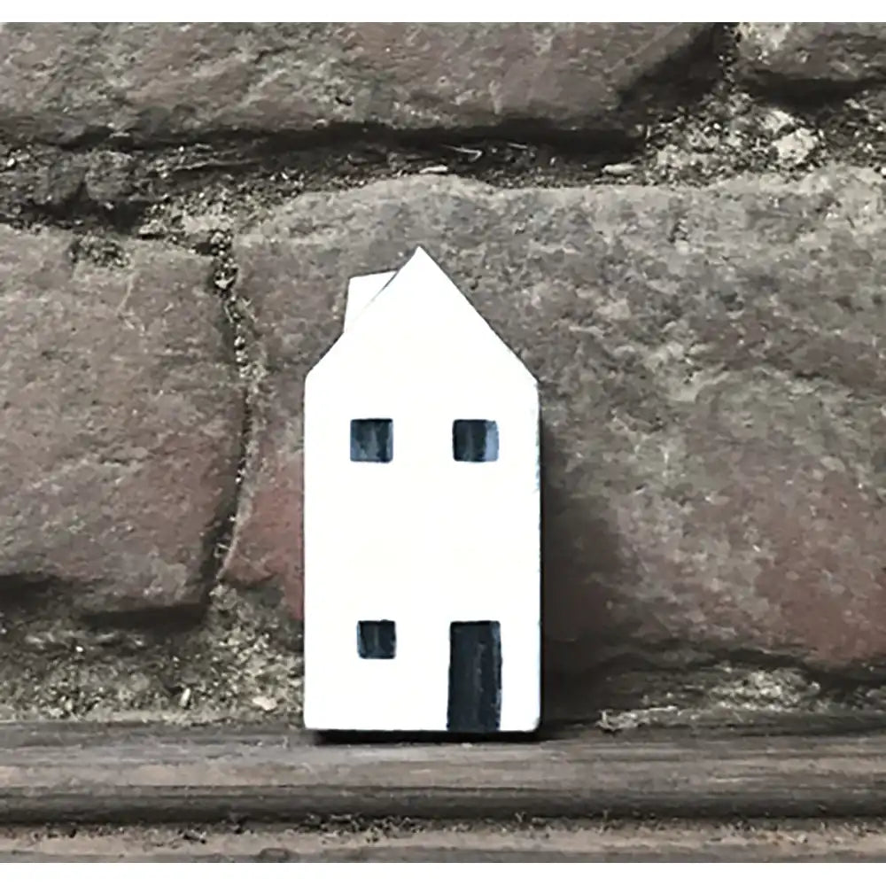 Small white house-shaped object on a stone surface