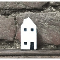 Small white house-shaped object on a stone surface