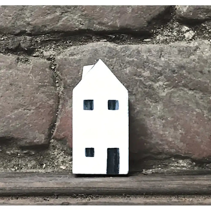 Small white house-shaped object on a stone surface