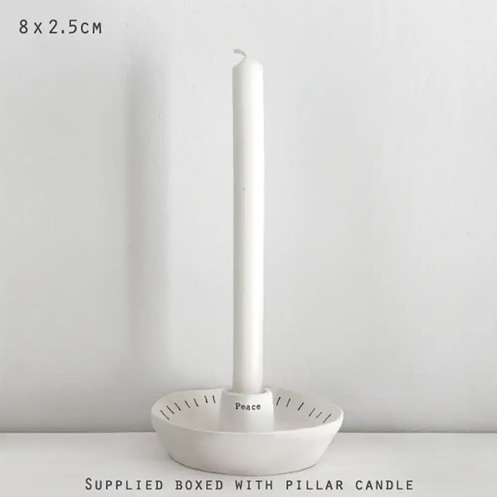 White candle holder with a pillar candle on a white background