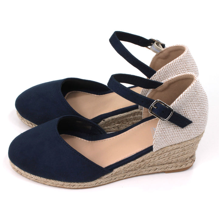 Heeled navy blue suede effect sandals. Slim ankle straps adjusted by small silver buckles. Espadrille soles. Side view.