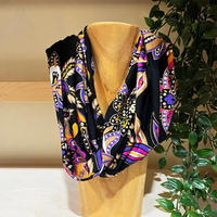 Black based snood with a bright multicoloured paisley print on it. 