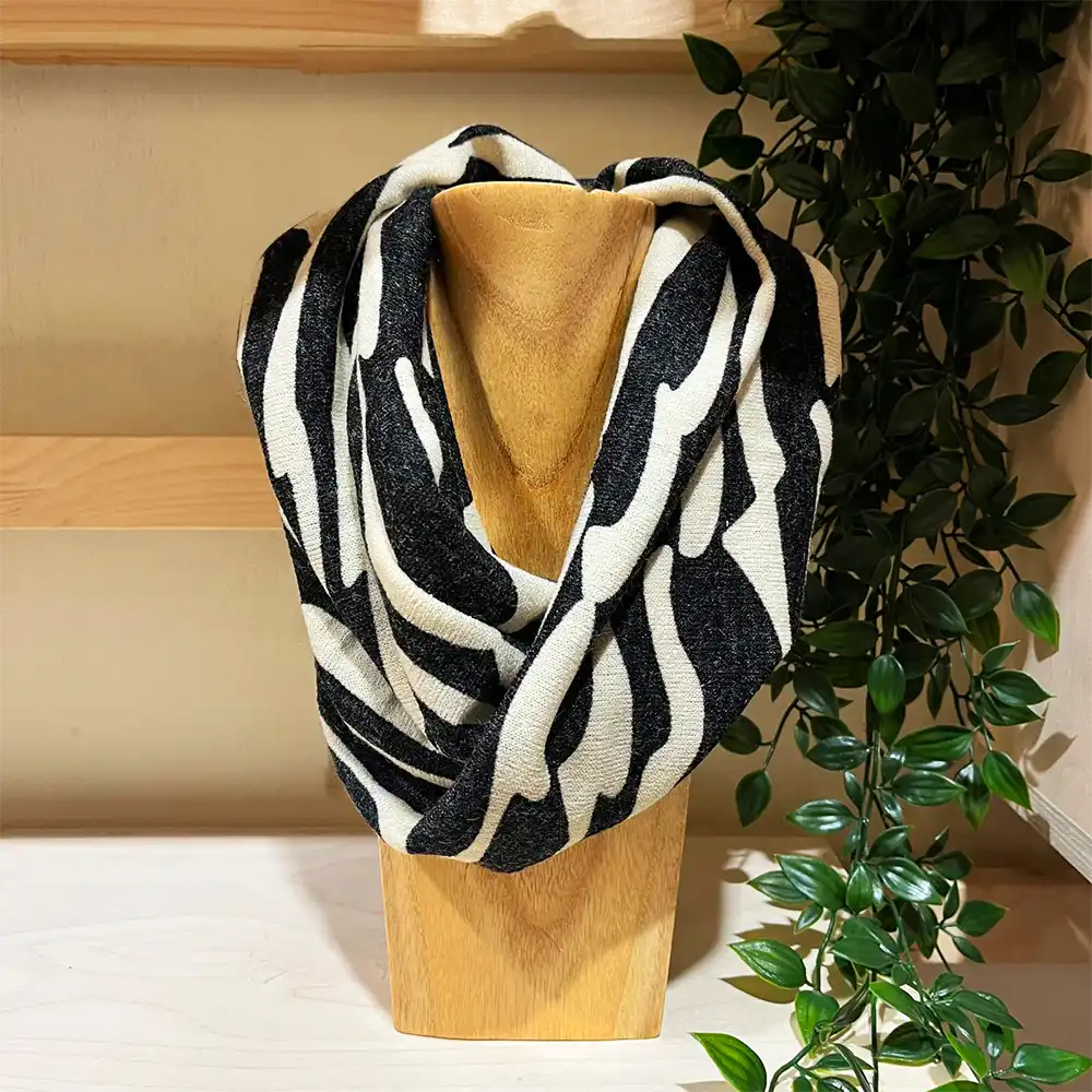 Black and white ecru snood on a wooden stand.