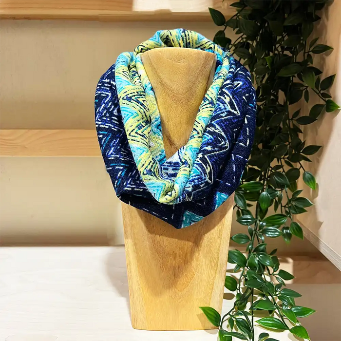 Blue and yellow aztec patterned snood on a wooden stand. 