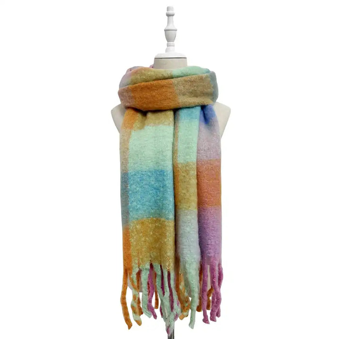 Multicolored plaid scarf with tassels on a mannequin against a white background
