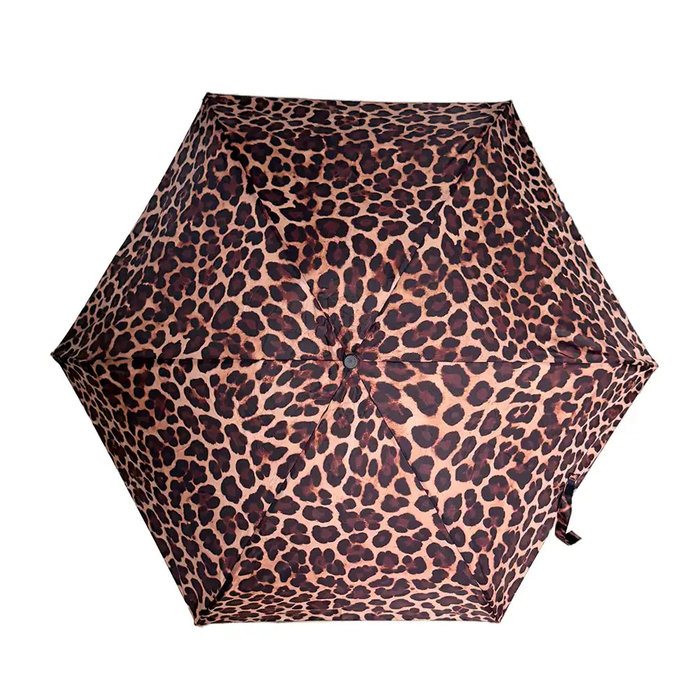 A top-down view of a compact umbrella with a leopard print pattern, featuring dark brown and black spots on a warm tan background, isolated on a white background.