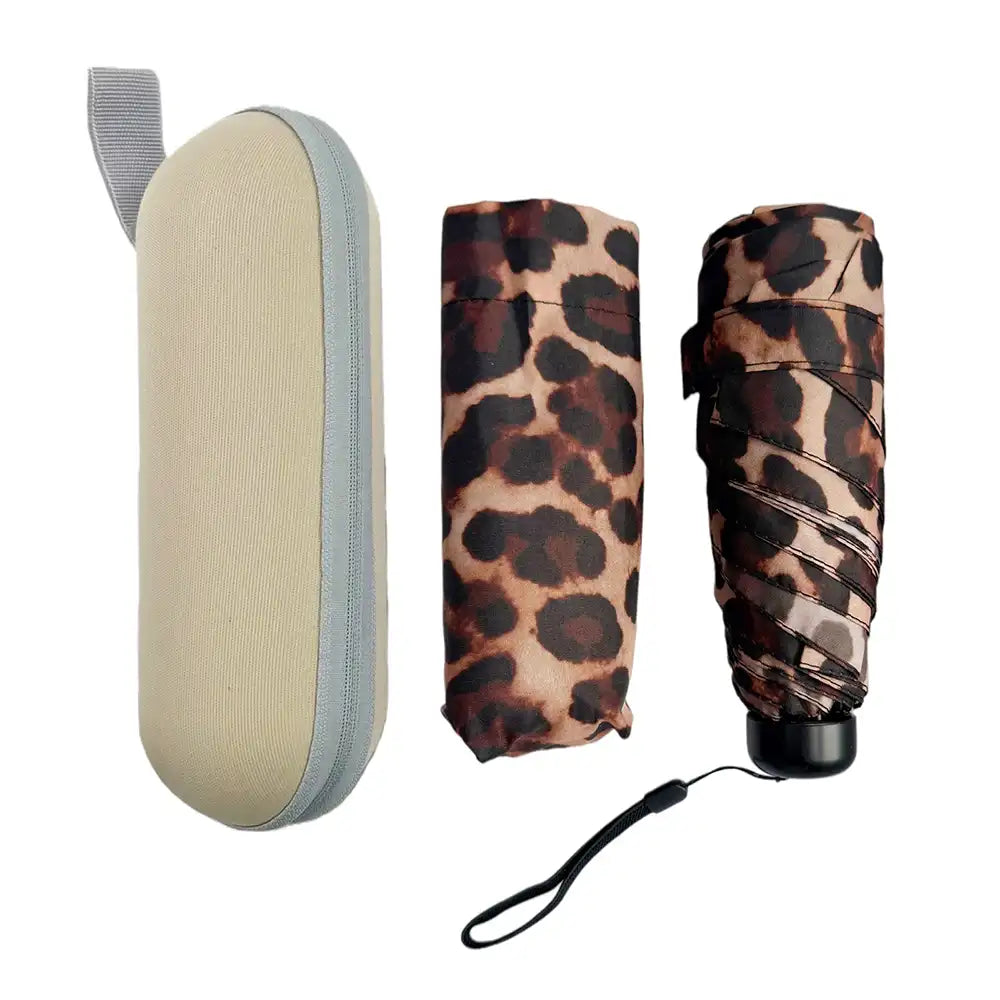A compact umbrella set shown on a plain white background, including a light beige hard case with gray trim, a folded leopard-print umbrella in tan and brown, and another folded umbrella with a matching leopard pattern and wrist strap.