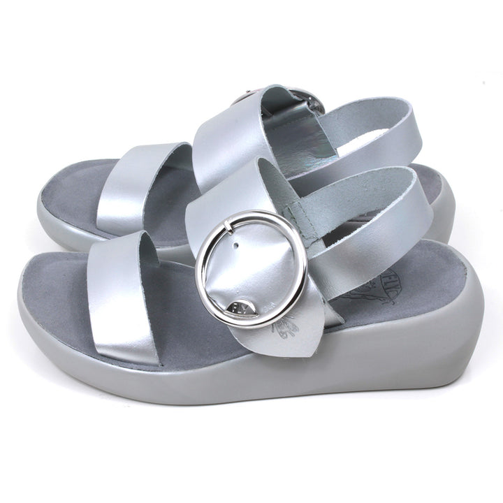 Fly London Mirror sandals in silver colour. Grey soles and footbeds. Large silver buckles on foot strap. Side view
