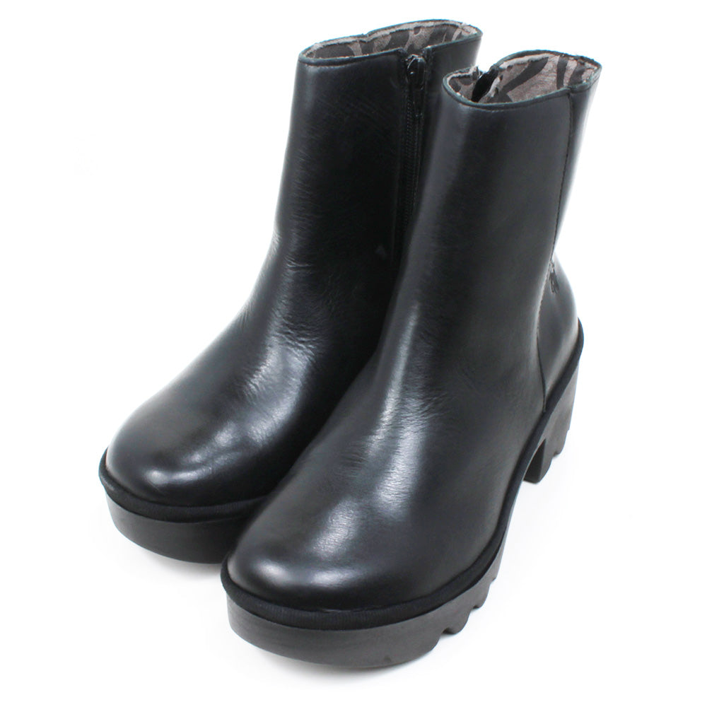 Fly London black ankle boots with zip fastening. Leather with chunky soles. Angled view.