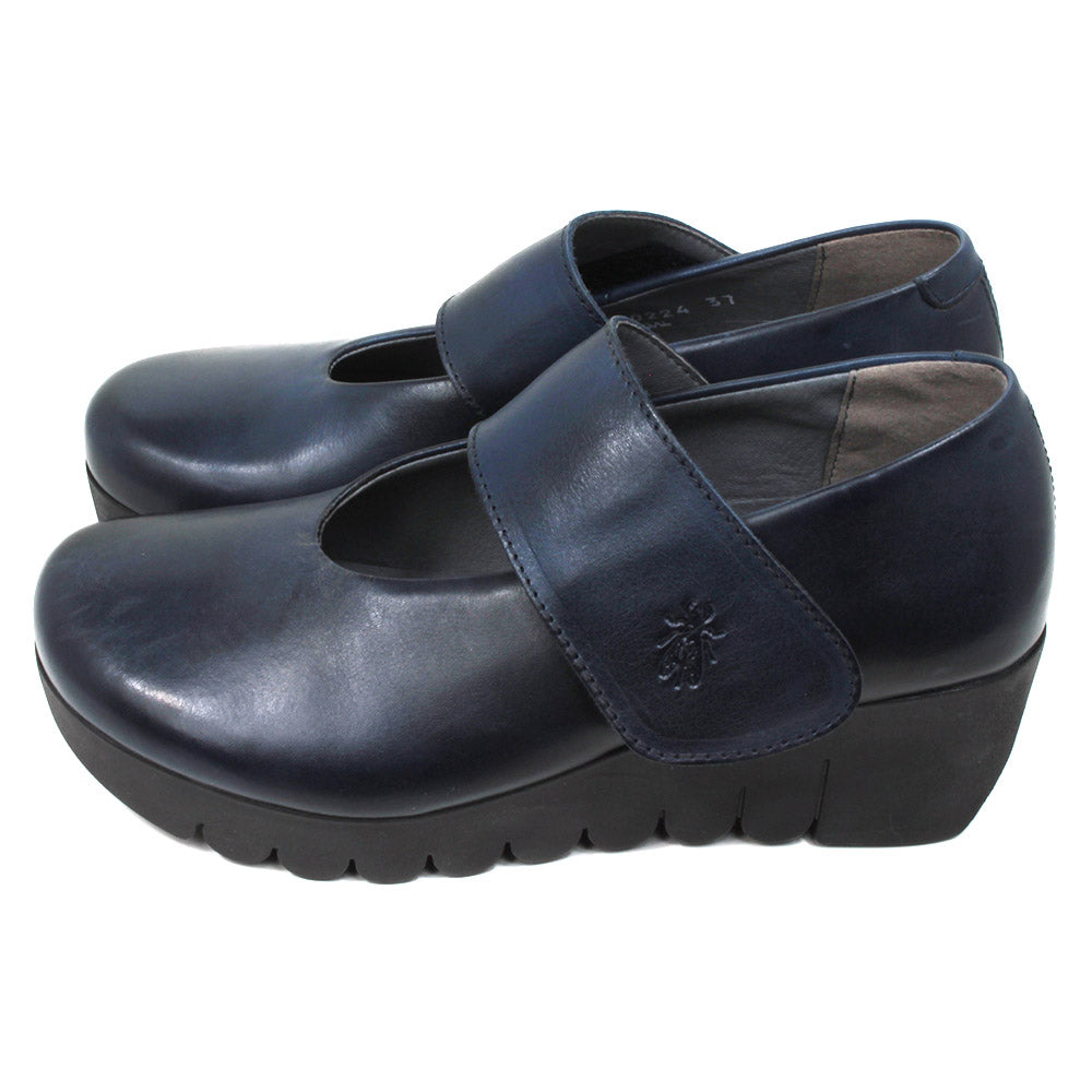 Fly London navy blue chunky wedge soled Mary Jane shoes with wrap over straps. Side view.