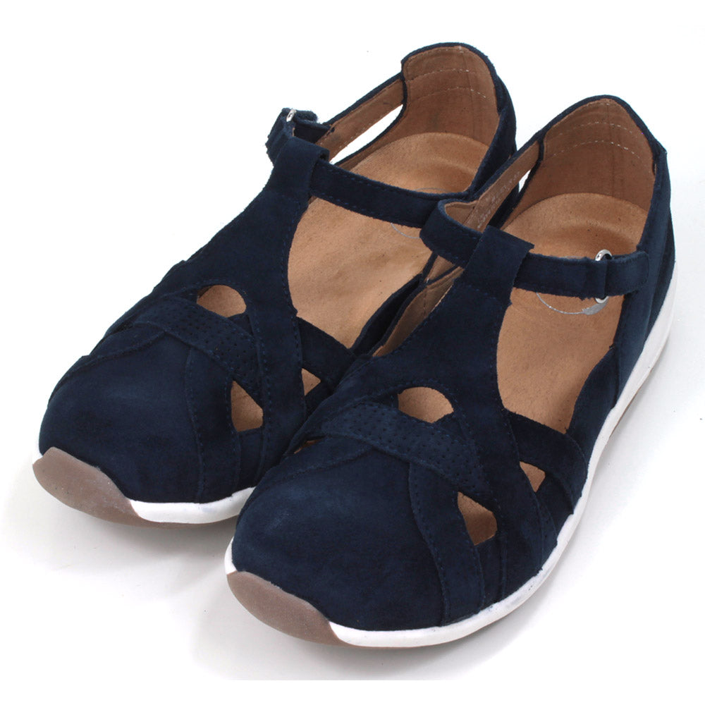 Full foot and heel covering sandals in navy blue suede leather. White soles. Adjustable velcro straps. Angled view.