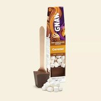Gnaw Caramel hot chocolate spoon packaging with a spoon and marshmallows on a beige background