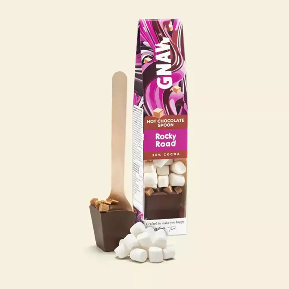Hot chocolate spoon with rocky road flavor packaging on a beige background