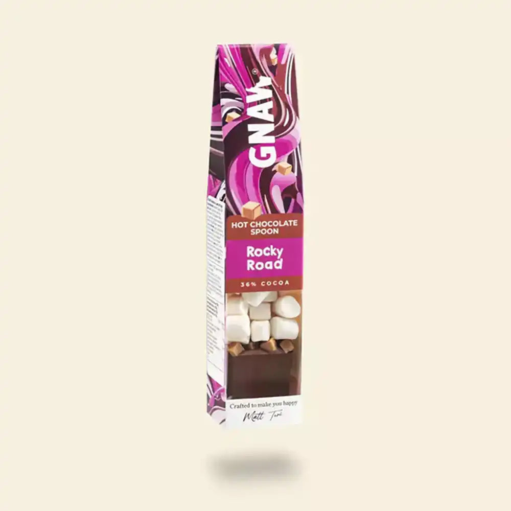 Hot chocolate spoon with rocky road flavor packaging on a beige background
