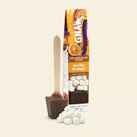 Ginax Seville Orange hot chocolate with marshmallows and a spoon on a beige background
