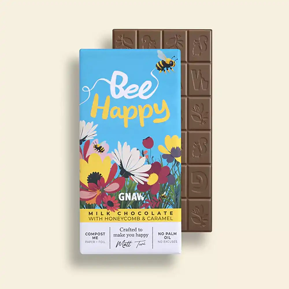 Chocolate bar with 'Bee Happy' packaging featuring flowers and a bee on a beige background