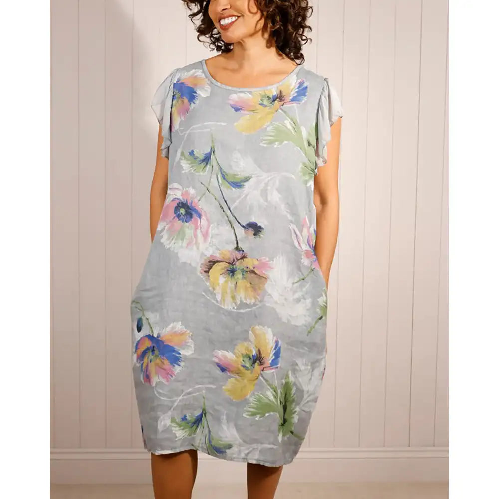 Woman wearing a floral dress against a neutral background