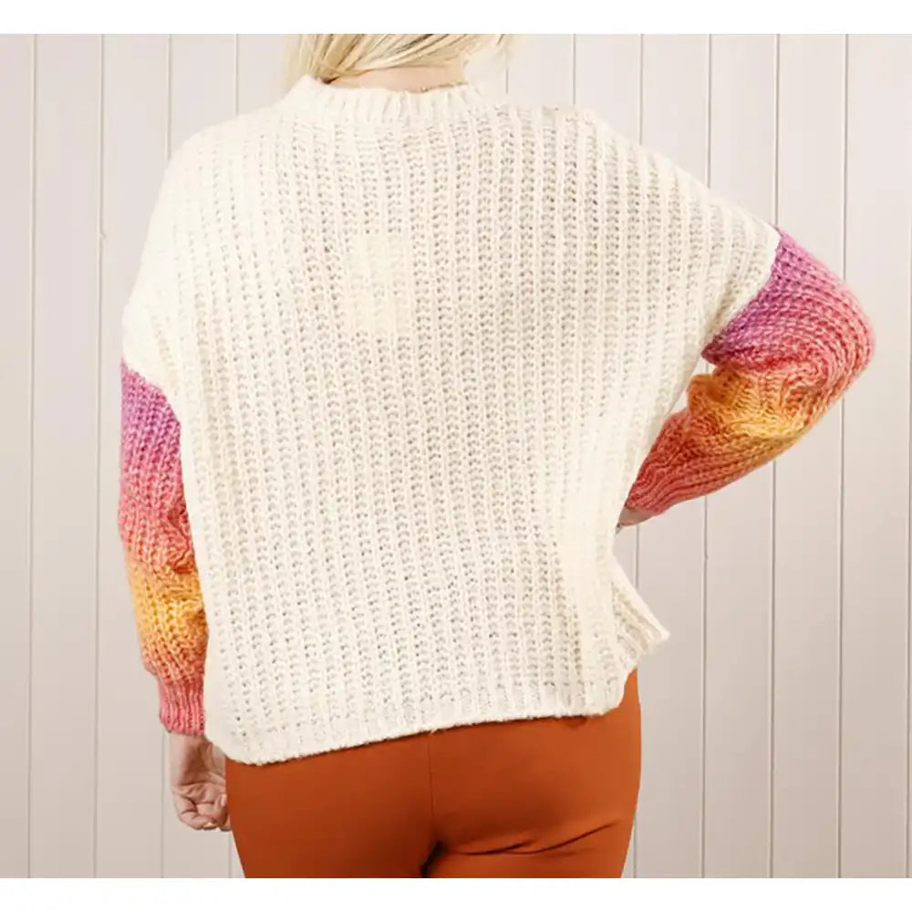 Person wearing a colorful knit sweater with a white background