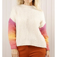 Person wearing a white sweater with colorful sleeves against a light background