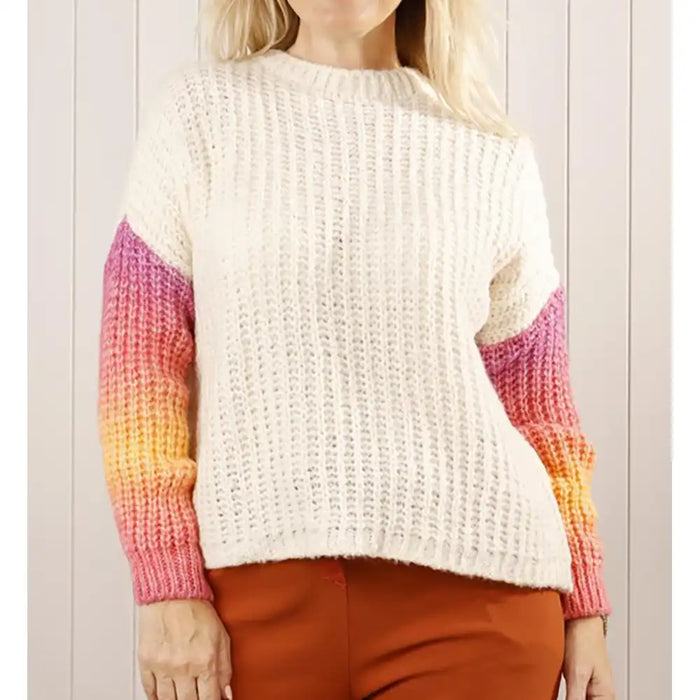 Person wearing a white sweater with colorful sleeves against a light background